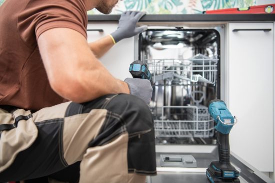 Plumbing Technician Installing a New Dishwasher