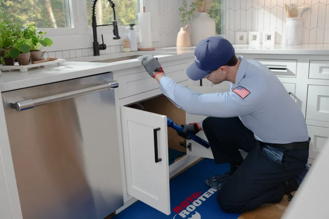 ROTO-ROOTER: YOUR LEAK DETECTION & REPAIR EXPERTS tech inspecting drain