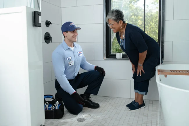 We Know Drain Cleaning tech talking with customer about drain